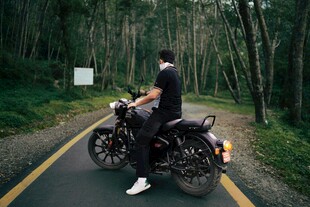 男子骑行于林间公路