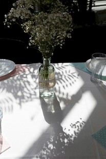 桌布上插着白花的玻璃瓶