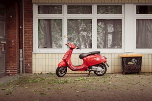 复古红色踏板摩托车靠墙停放