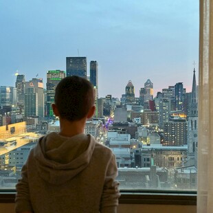 男孩窗前眺望城市风景