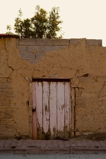 老旧土墙旁的斑驳木门