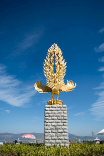 金色雕塑矗立蓝天之下