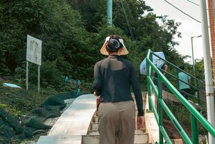 女子漫步于绿意盎然小径