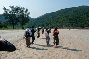 户外徒步队伍行进在沙地