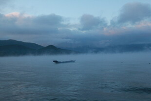海上孤舟伴云雾美景