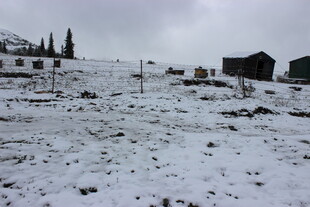 雪覆山地与远处小屋