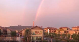 夕阳下城市上空的美丽彩虹