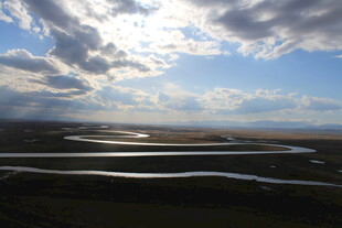 草原蜿蜒河流与蓝天白云