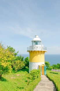 海边草地中的黄色灯塔