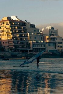 夕阳下海滩边的高楼与行人
