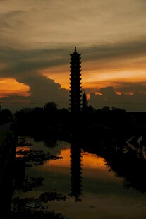 夕阳下古塔映于水面