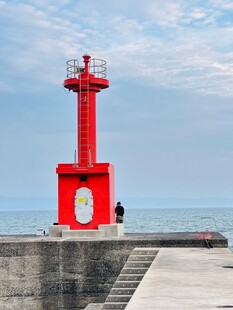 海边红灯塔下的孤独身影