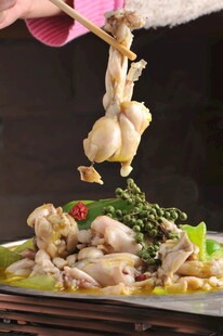 筷子夹起鲜嫩牛蛙美食