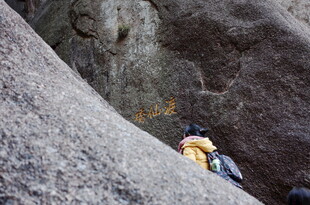 攀岩者于巨石间奋力攀爬