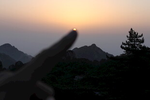 夕阳下手指比耶的山间美景