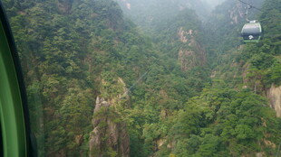 缆车穿梭于青山云雾间