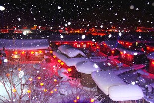 雪夜灯火映照的温馨村落