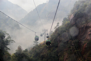 山间缆车载客穿梭云雾中