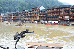 河畔吊脚楼前的跳跃瞬间