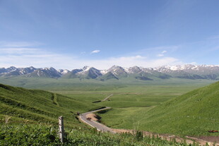 草原蜿蜒小路与远处雪山