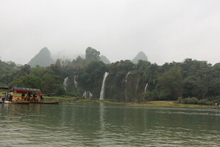 雾中湖畔瀑布与小船