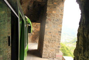 石砌建筑旁的绿色车厢