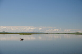 平静湖面孤舟映蓝天