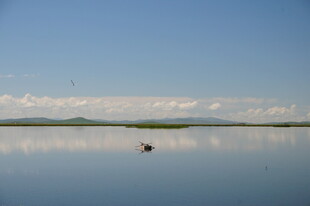平静湖面小船映蓝天白云