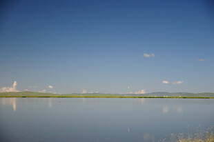 平静湖面映蓝天与远岸