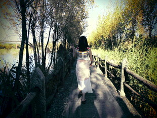 女子漫步于林间木栈道