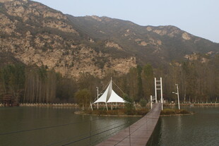 湖畔栈桥与山间白色建筑