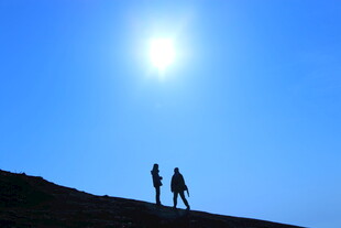 阳光下的两人登山剪影