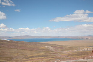 广阔草原与远处蓝色水域