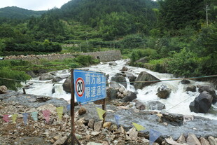 山间溪流旁的蓝色指示牌