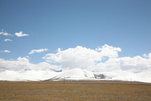 草原蓝天与远处雪山美景