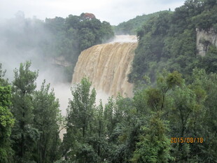 壮观瀑布隐于葱郁山林间