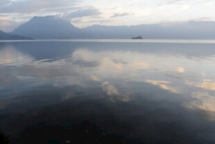 平静湖面倒映天空与远山