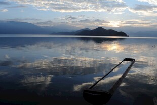 湖畔日出美景中的长杆倒影
