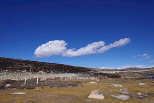 蓝天旷野间的白云与石景