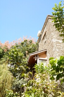 石屋隐于绿植蓝天间