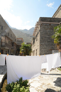 户外石屋旁晾晒的白色织物