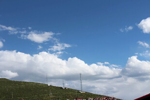 蓝天白云下的山坡风景