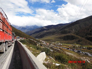 公路上的红色货车与山景