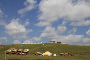 草原上的多彩帐篷与蓝天