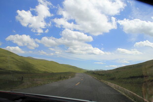 公路穿行于青山蓝天白云间