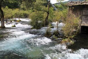 山间湍急溪流旁的小屋