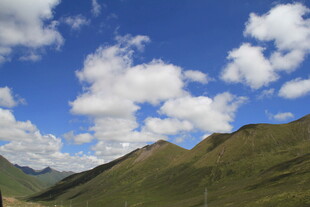 蓝天白云下的翠绿山峦