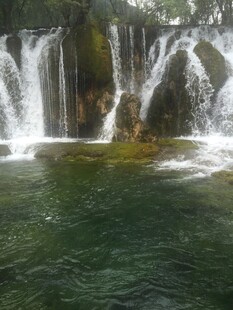 壮观瀑布下的碧绿潭水