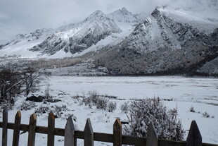 冬日雪山下的木栅栏风景