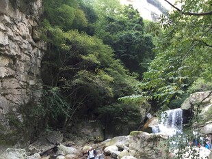 山间瀑布下的休闲人群